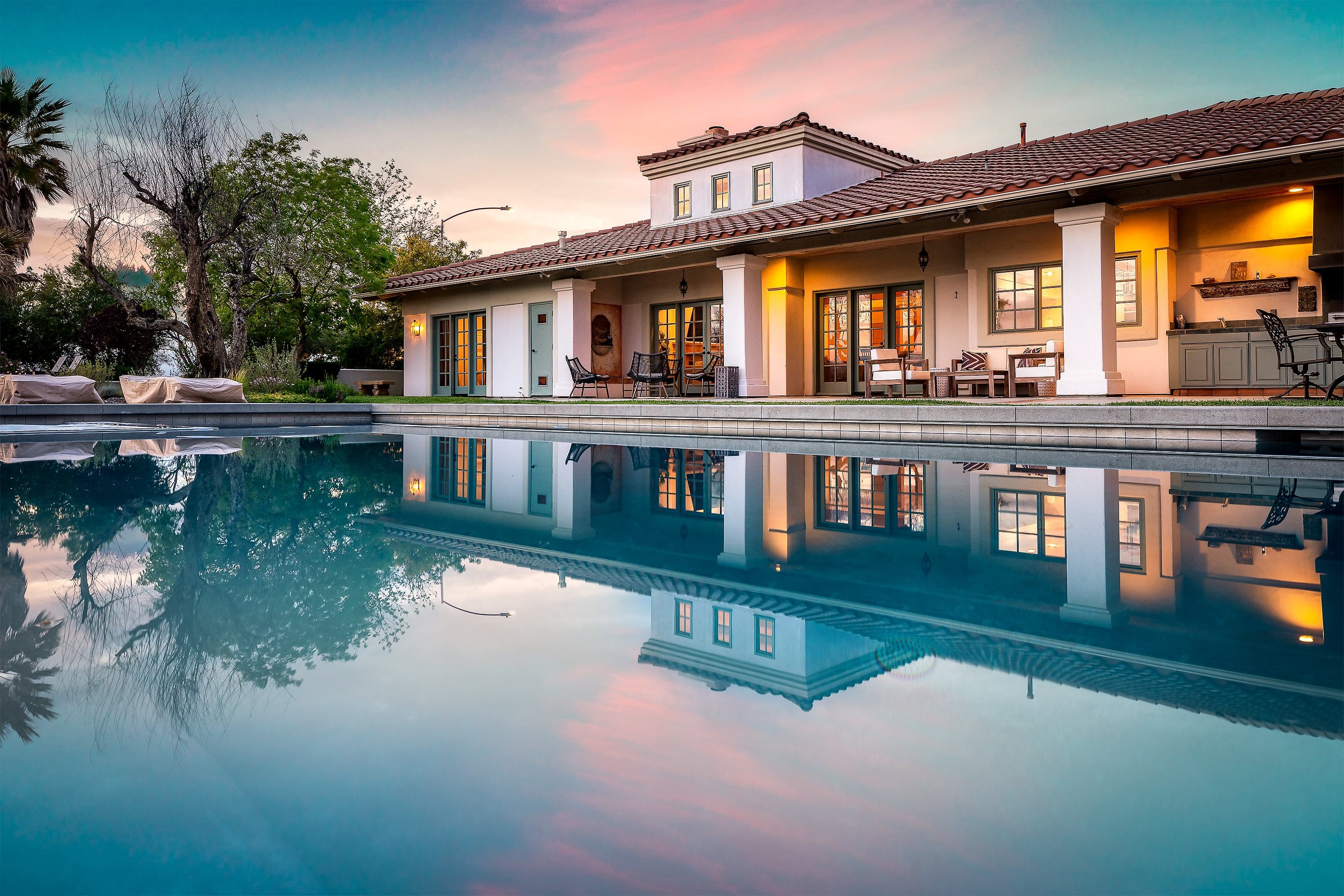 An AvantStay managed luxury villa with a lit pool at twilight